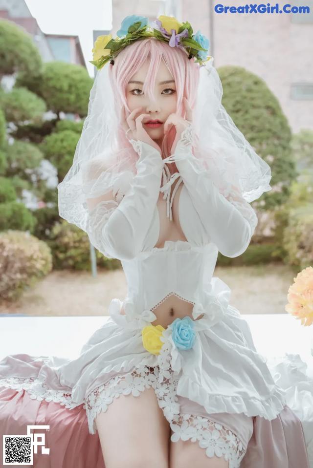 A woman in a wedding dress sitting on a bed.