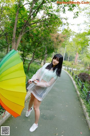 A woman leaning against a tree with her eyes closed.