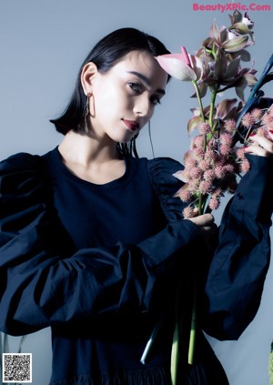 A woman in a black shirt is posing for a magazine.