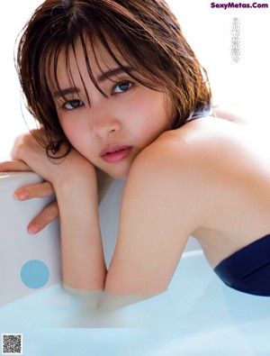 A woman with wet hair is posing for a magazine.