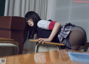 A woman in a school uniform is bent over on a desk.