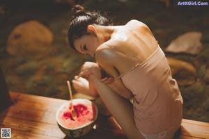 A woman in a pink top and white panties.