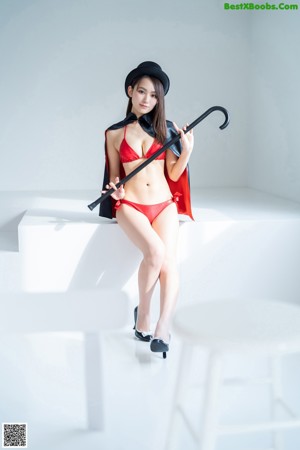 A woman in a red bikini and a black hat.