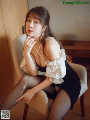 A woman sitting on a chair in a room.