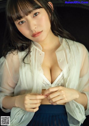 A woman in a beige tank top posing for a picture.