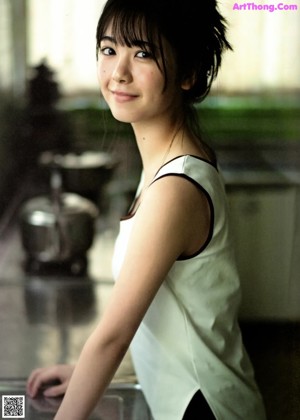 A woman holding a brush in front of her face.