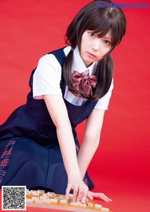 A woman in a school uniform is posing for a picture.