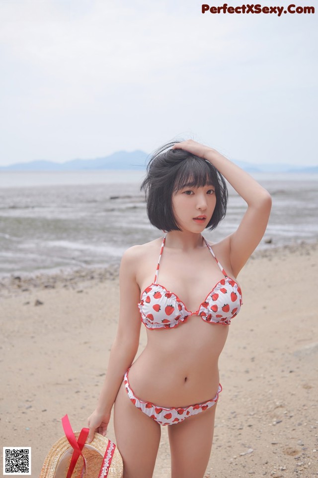 A woman in a bikini standing on a beach.