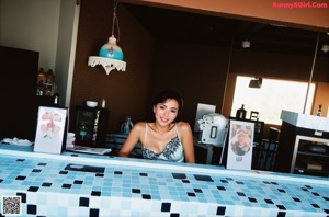 A naked woman sitting on top of a pool table.