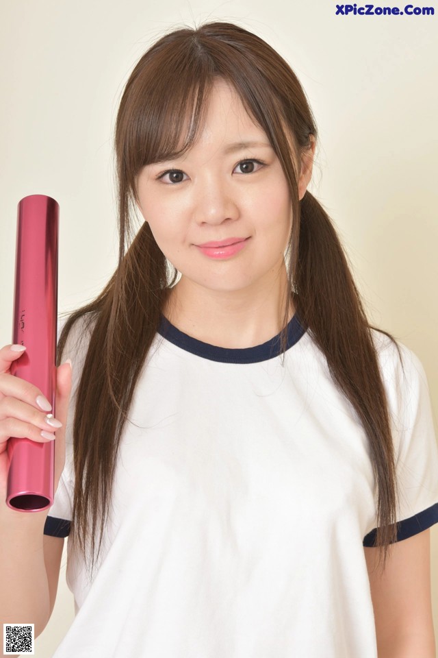 A woman holding a pink curling iron in her hand.