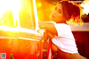 A woman sitting on the back of a red truck.