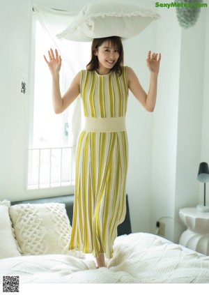 A woman in a purple dress standing in front of a mirror.