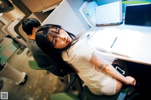 A woman sitting at a desk with a laptop computer.